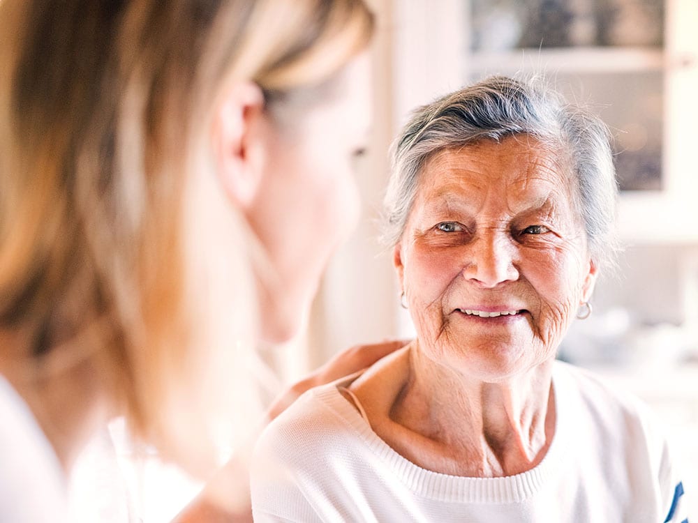 Woman speaking with elderly woman psychology counselling 